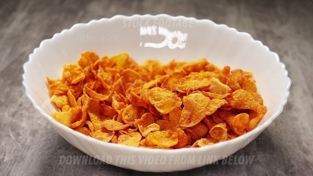 'Cooking fast food breakfast from yellow cornflakes in slow motion'